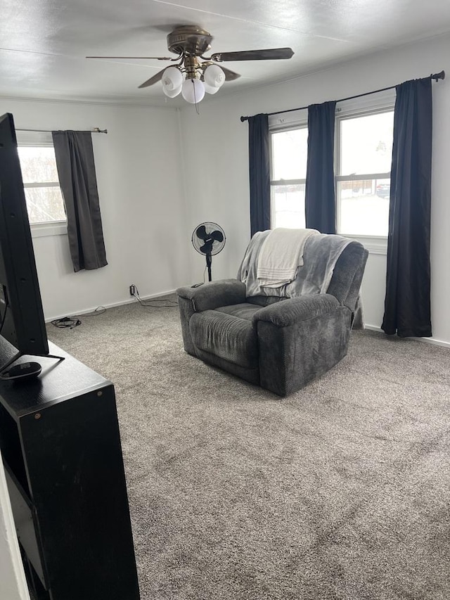 carpeted living room with a ceiling fan and baseboards