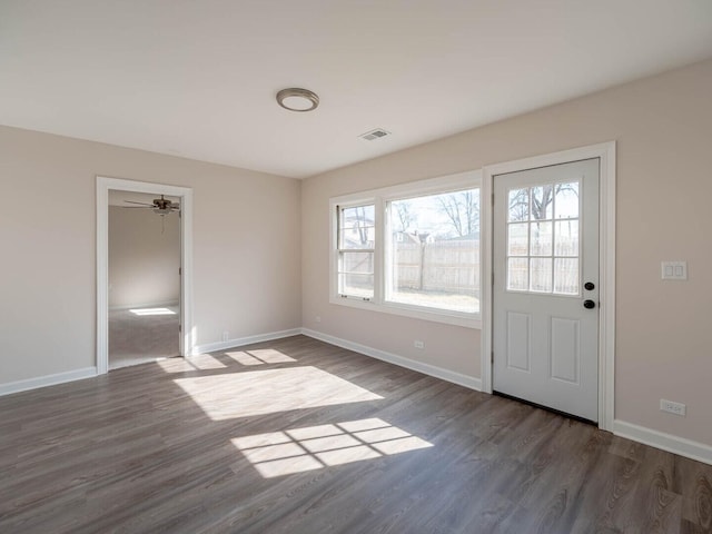 interior space featuring dark wood-type flooring, visible vents, and baseboards