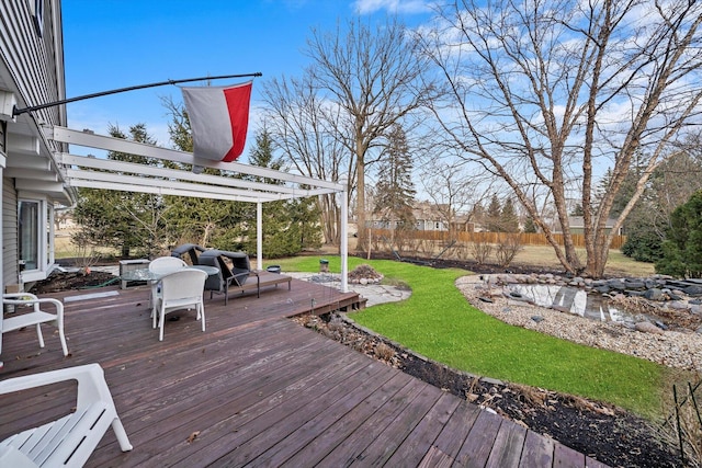 wooden terrace featuring fence and a yard