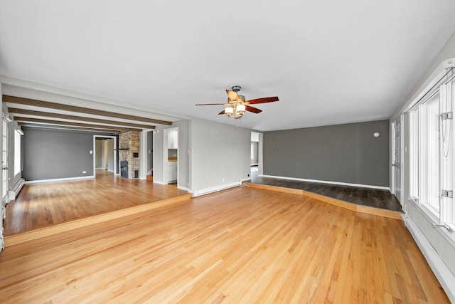 unfurnished living room with ceiling fan, a baseboard radiator, wood finished floors, and baseboards