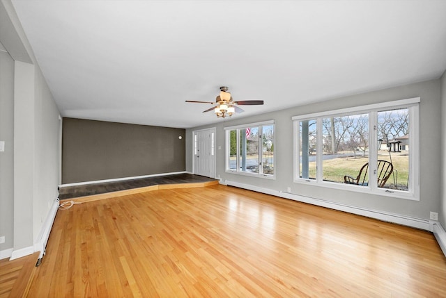 unfurnished living room featuring a baseboard radiator, wood finished floors, a ceiling fan, and baseboards