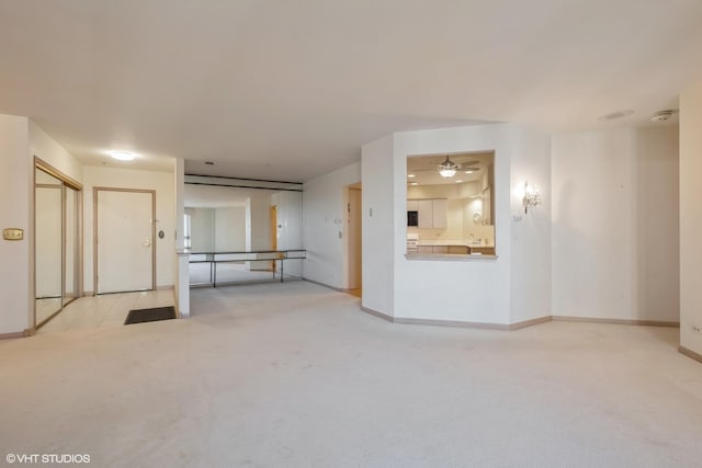 unfurnished room featuring baseboards and light carpet