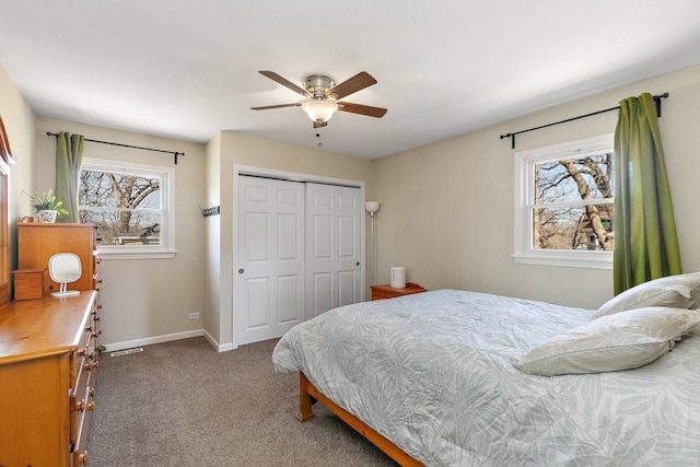 carpeted bedroom with a closet, baseboards, and ceiling fan