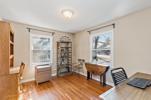 office area featuring light wood-type flooring and baseboards