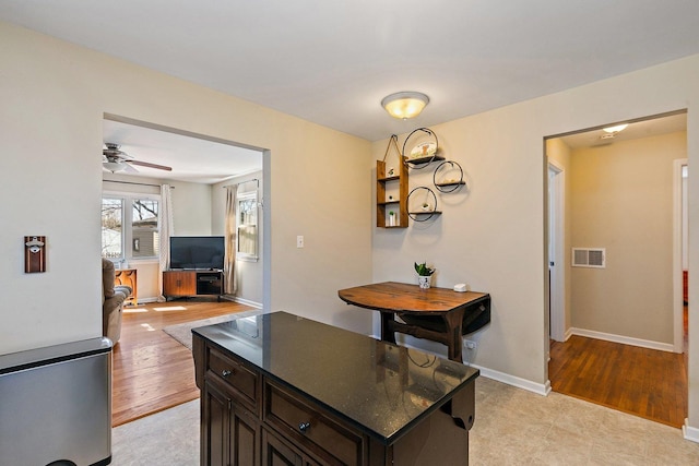 kitchen with light wood-type flooring, visible vents, dark brown cabinetry, baseboards, and ceiling fan