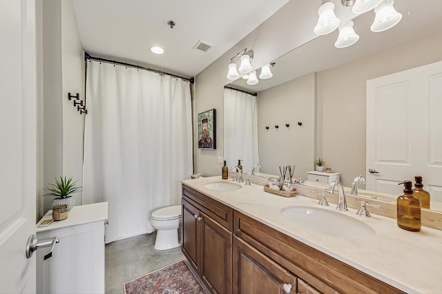 bathroom with visible vents, a sink, toilet, and double vanity