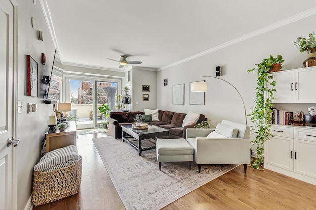 living area featuring light wood-style floors, crown molding, and ceiling fan