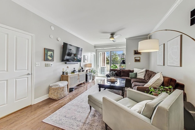 living area featuring ceiling fan, crown molding, baseboards, and wood finished floors