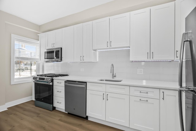 kitchen featuring light countertops, appliances with stainless steel finishes, a sink, and white cabinetry