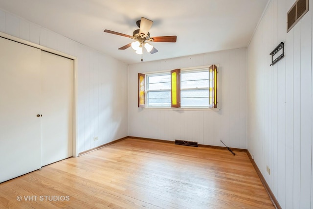 unfurnished bedroom with light wood finished floors, a closet, visible vents, and a ceiling fan