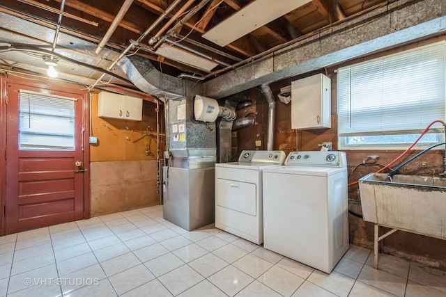 laundry room featuring a healthy amount of sunlight, laundry area, a sink, and washer and dryer