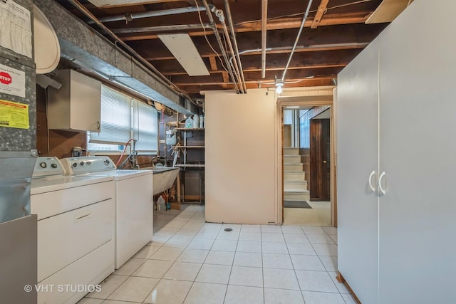 clothes washing area featuring independent washer and dryer, a sink, and light tile patterned floors