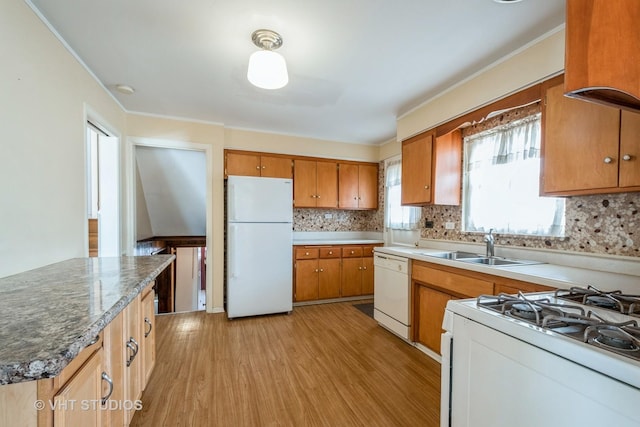 kitchen featuring white appliances, a sink, light wood-style flooring, and backsplash