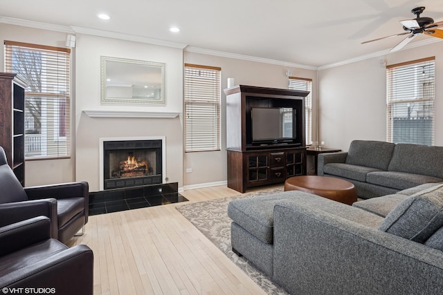 living area featuring a fireplace with flush hearth, ornamental molding, wood finished floors, and recessed lighting