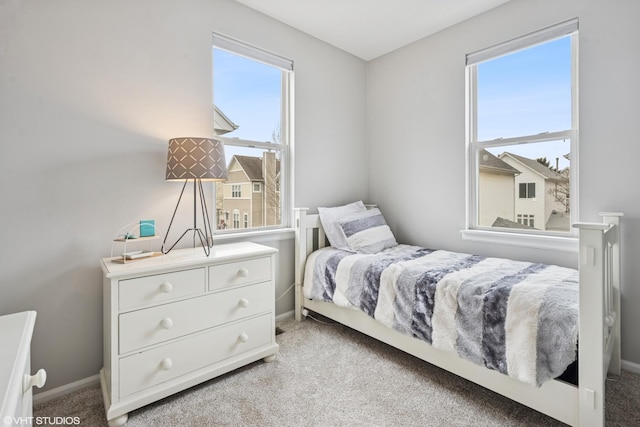 bedroom with light carpet and baseboards