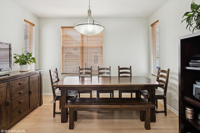 dining room featuring light wood-style flooring and baseboards