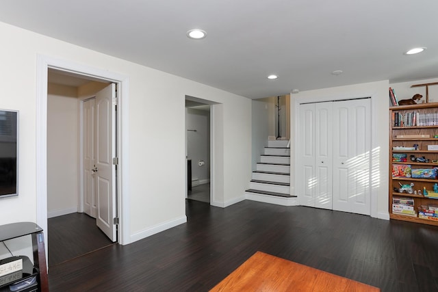 interior space featuring baseboards, stairway, dark wood-type flooring, and recessed lighting