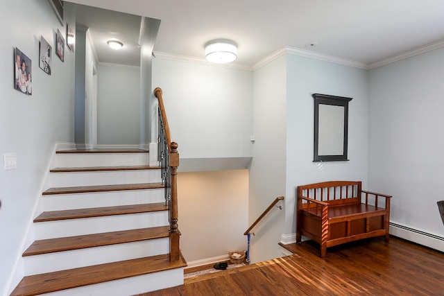 stairs featuring baseboards, ornamental molding, baseboard heating, and wood finished floors