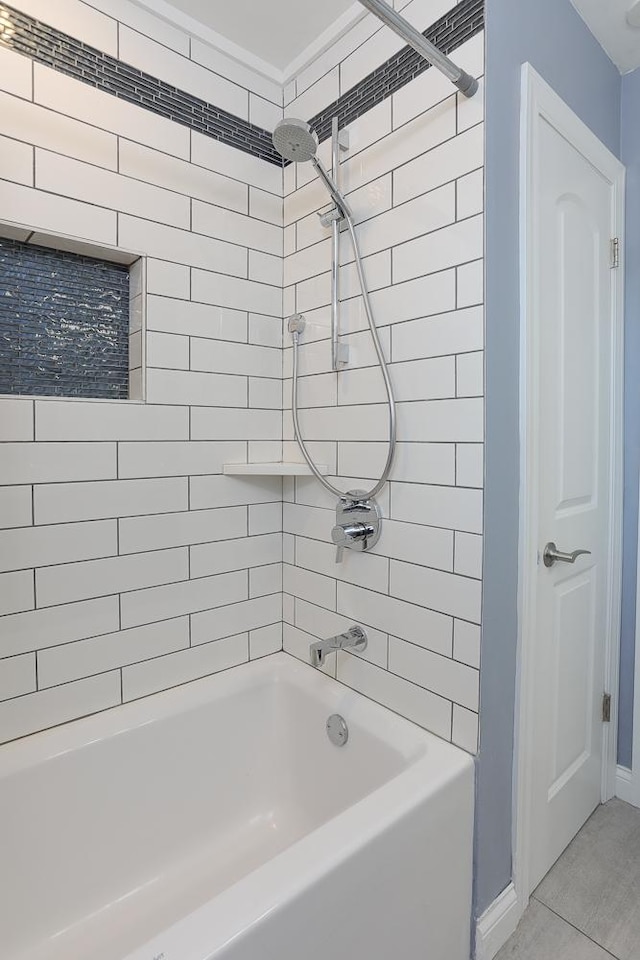 bathroom with shower / tub combination and baseboards