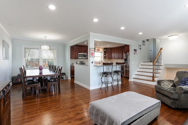 living area featuring dark wood-style floors, recessed lighting, crown molding, and stairway