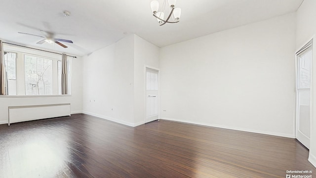 unfurnished room with dark wood finished floors, radiator, ceiling fan with notable chandelier, and baseboards