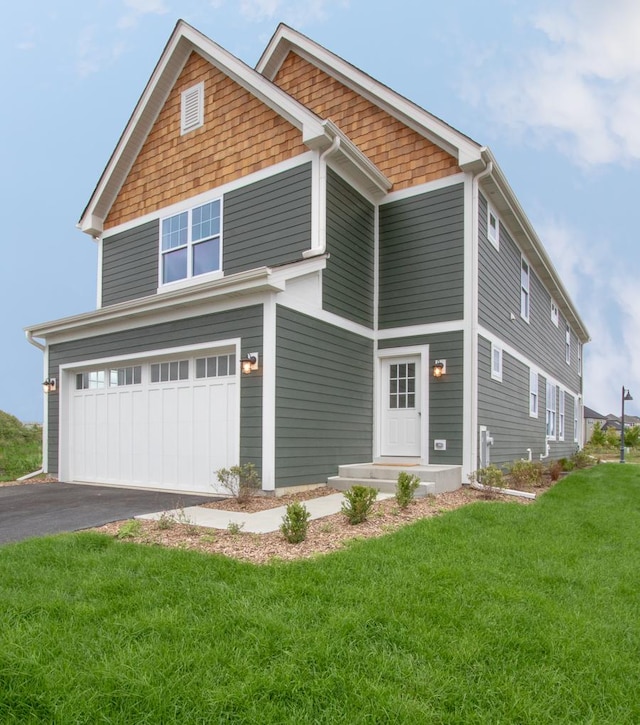 craftsman inspired home featuring an attached garage, aphalt driveway, and a front yard