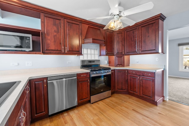 kitchen featuring stainless steel appliances, light wood-type flooring, custom exhaust hood, and light countertops