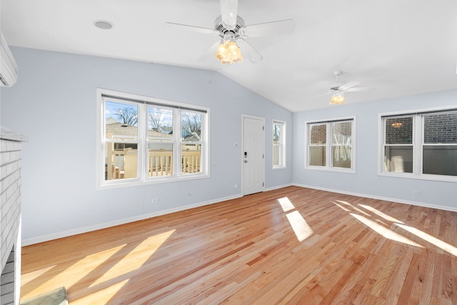 unfurnished living room with a ceiling fan, light wood-type flooring, vaulted ceiling, and baseboards