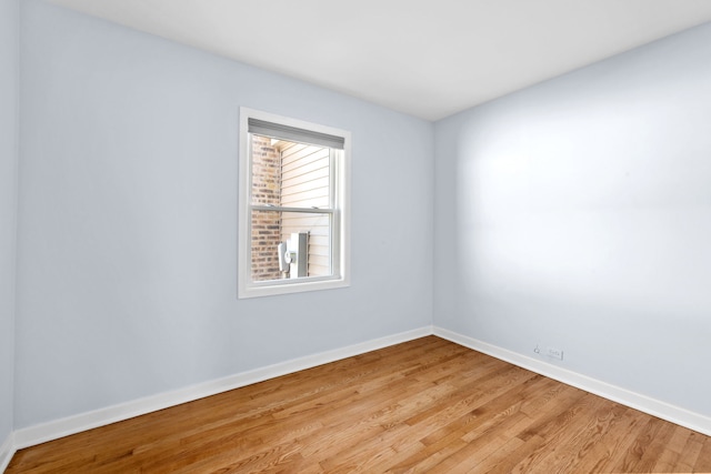 empty room with light wood finished floors and baseboards