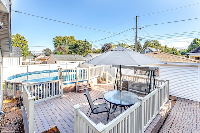 deck featuring a fenced backyard, outdoor dining area, and a fenced in pool