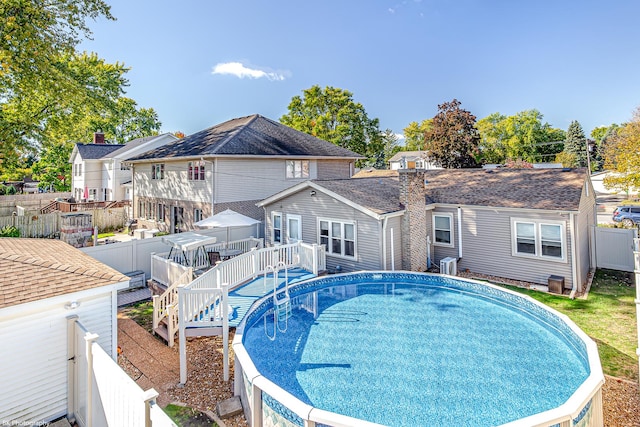 view of swimming pool featuring a fenced in pool, a fenced backyard, stairway, and a wooden deck