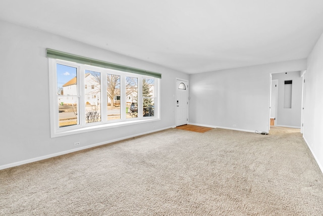 unfurnished room featuring baseboards and light colored carpet