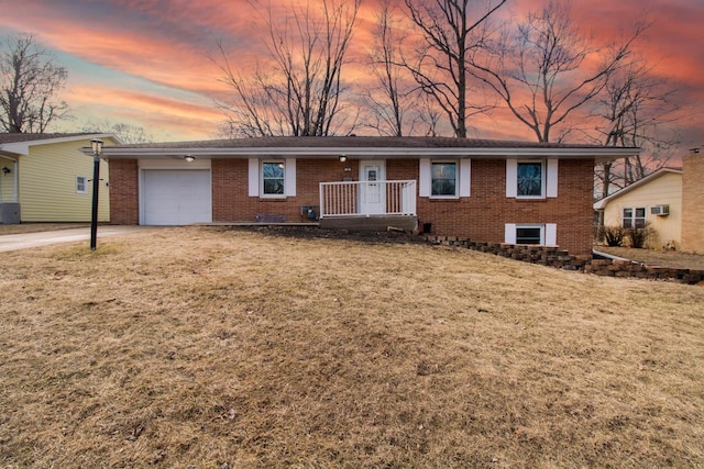 ranch-style home featuring an attached garage, a front lawn, concrete driveway, and brick siding