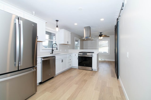 kitchen with extractor fan, white cabinetry, light countertops, appliances with stainless steel finishes, and light wood-type flooring