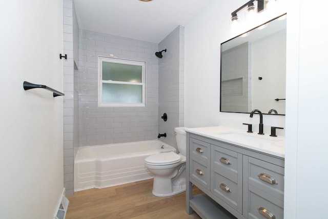 bathroom featuring toilet, vanity, wood finished floors, and shower / bathing tub combination