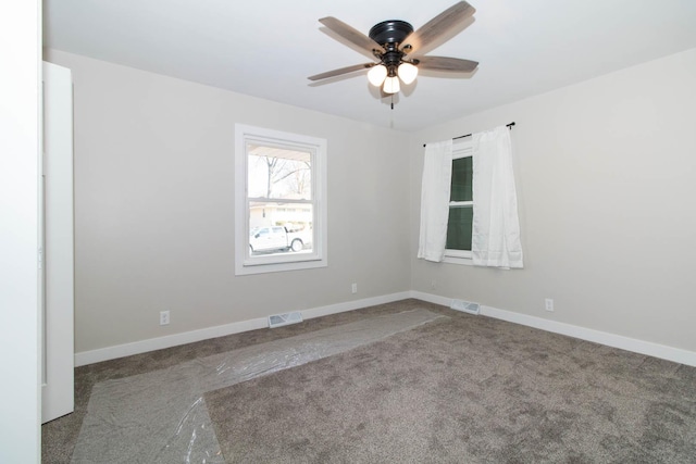 unfurnished room featuring baseboards, visible vents, ceiling fan, and carpet flooring