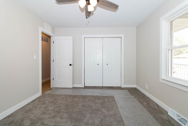 unfurnished bedroom with ceiling fan, visible vents, baseboards, a closet, and carpet