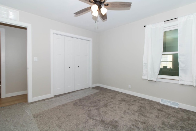 unfurnished bedroom with a closet, carpet flooring, visible vents, and baseboards