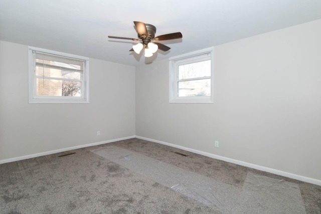 carpeted empty room with visible vents and baseboards