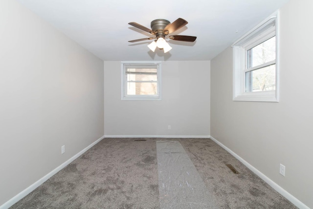 carpeted spare room with baseboards and a ceiling fan