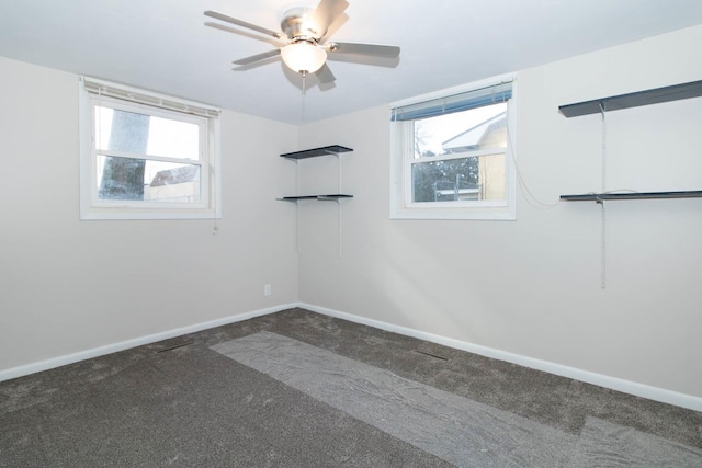 carpeted spare room with baseboards, ceiling fan, and a healthy amount of sunlight