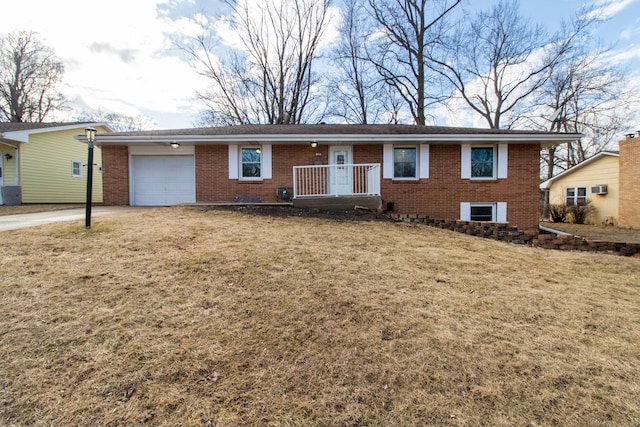 single story home featuring a front yard, concrete driveway, brick siding, and an attached garage