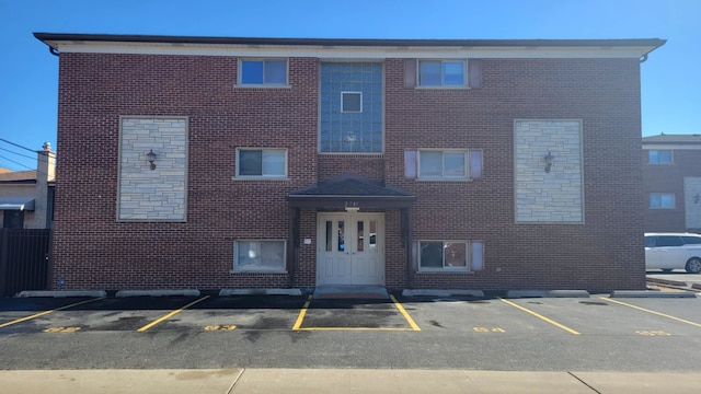 view of front of home featuring uncovered parking and brick siding