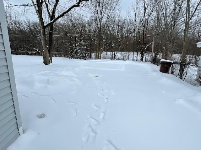 yard layered in snow featuring fence