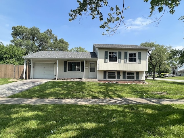 split level home featuring concrete driveway, a front lawn, an attached garage, and fence