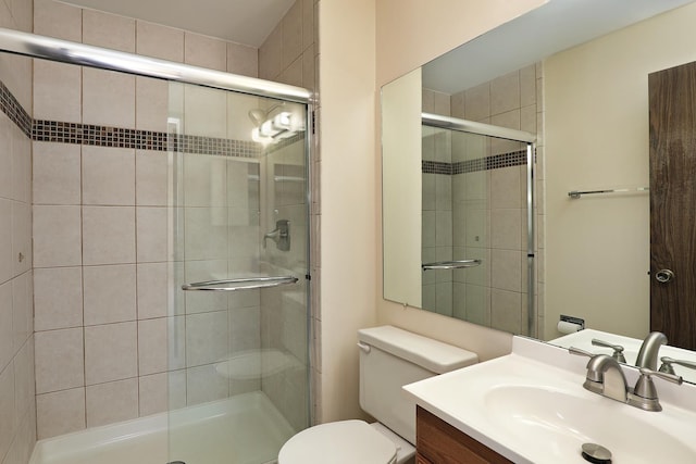 bathroom with toilet, a shower stall, and vanity