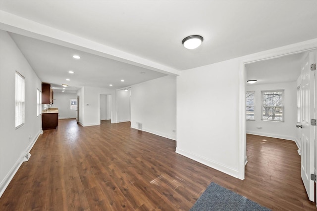 unfurnished living room with dark wood-style flooring, recessed lighting, visible vents, and baseboards