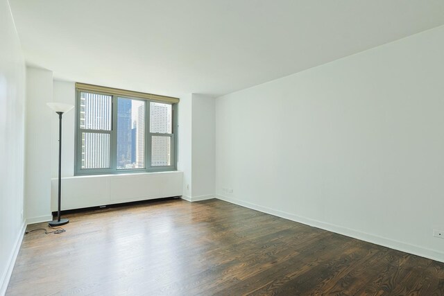 400 E Randolph St Unit 1824, Chicago, IL 60601 - unfurnished room featuring dark wood-style flooring, baseboards, and radiator heating unit