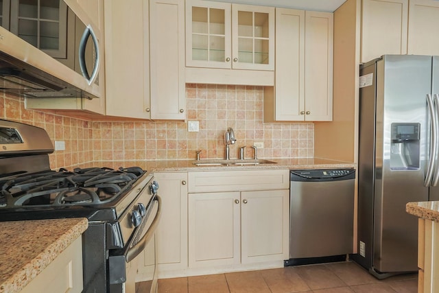 400 E Randolph St Unit 1824, Chicago, IL 60601 - kitchen with a sink, light stone counters, backsplash, glass insert cabinets, and appliances with stainless steel finishes