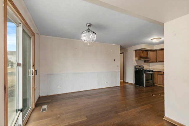 interior space with dark wood-style floors, wainscoting, visible vents, and a notable chandelier